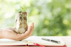 Persona que sosté un pot amb diners i una planta creixent. És una metàfora sobre la relació entre diners i abundància